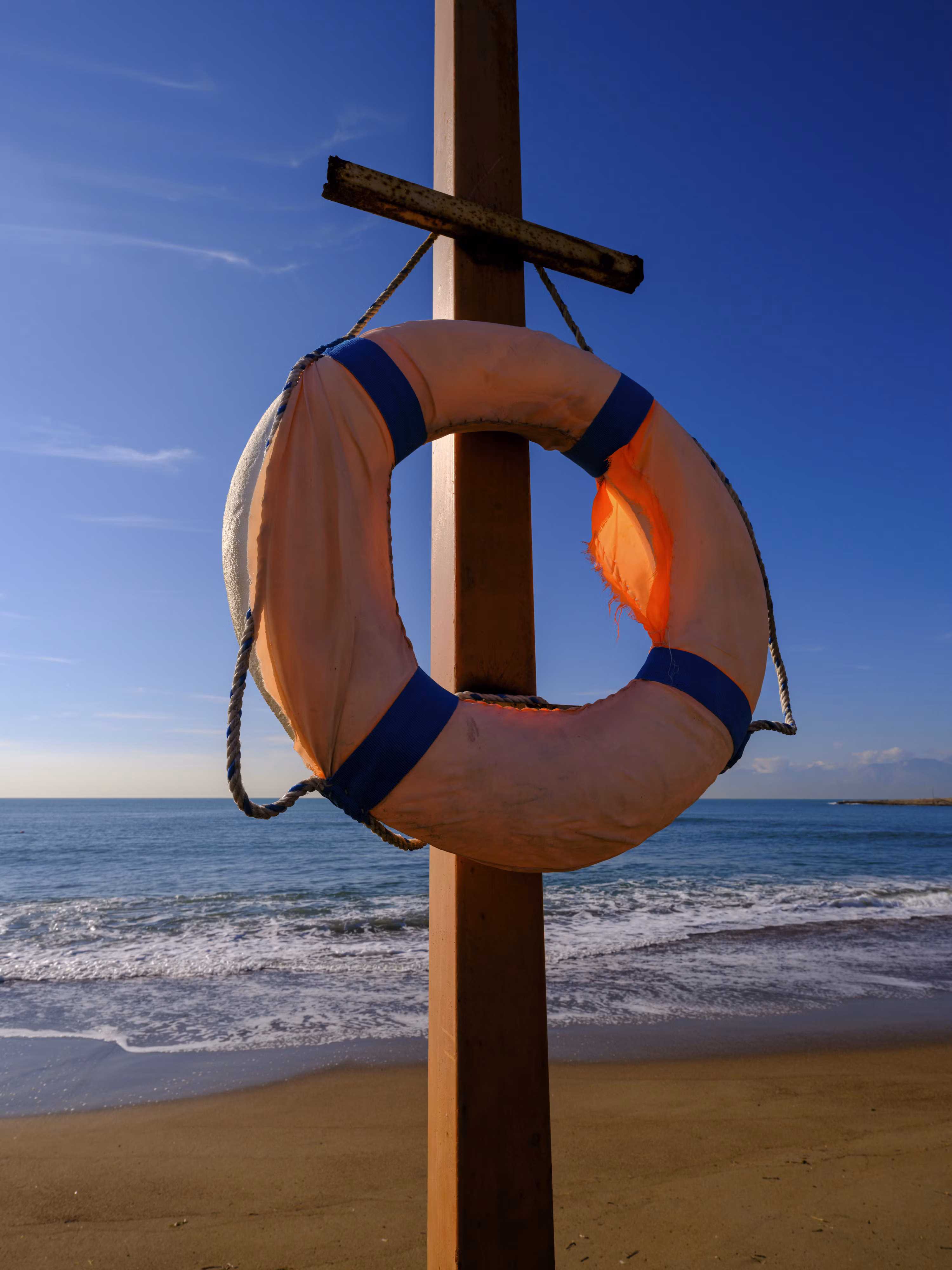 A cluster of red-and-white striped life preservers floating on calm turquoise water along the swim line.