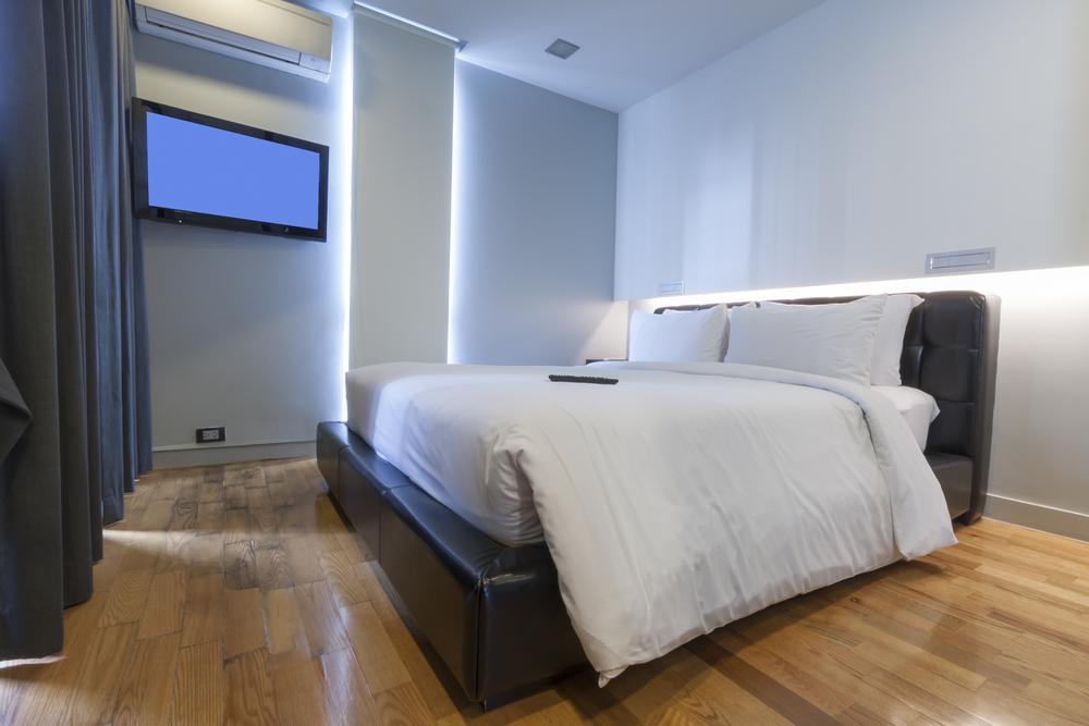 A clean, air-conditioned resort room with white linens and a soft glow from the bedside lamp.