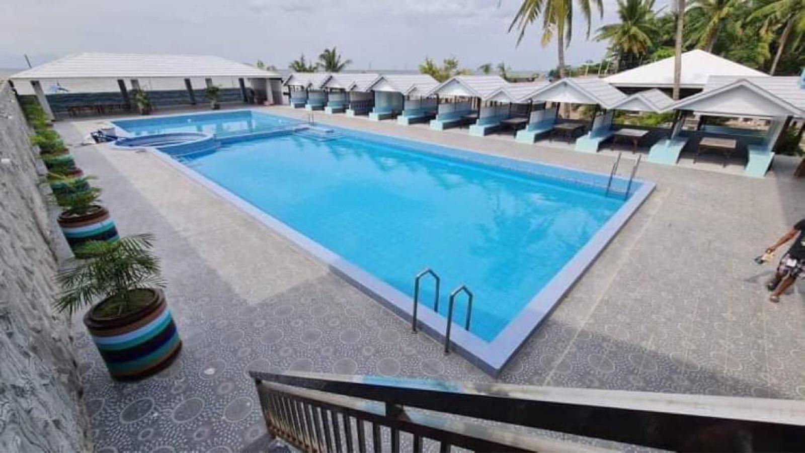 Blue pool water and shaded cabanas at Your Resort on a sunny day